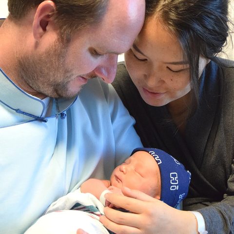 Travis and Tunga holding newborn Dalai
