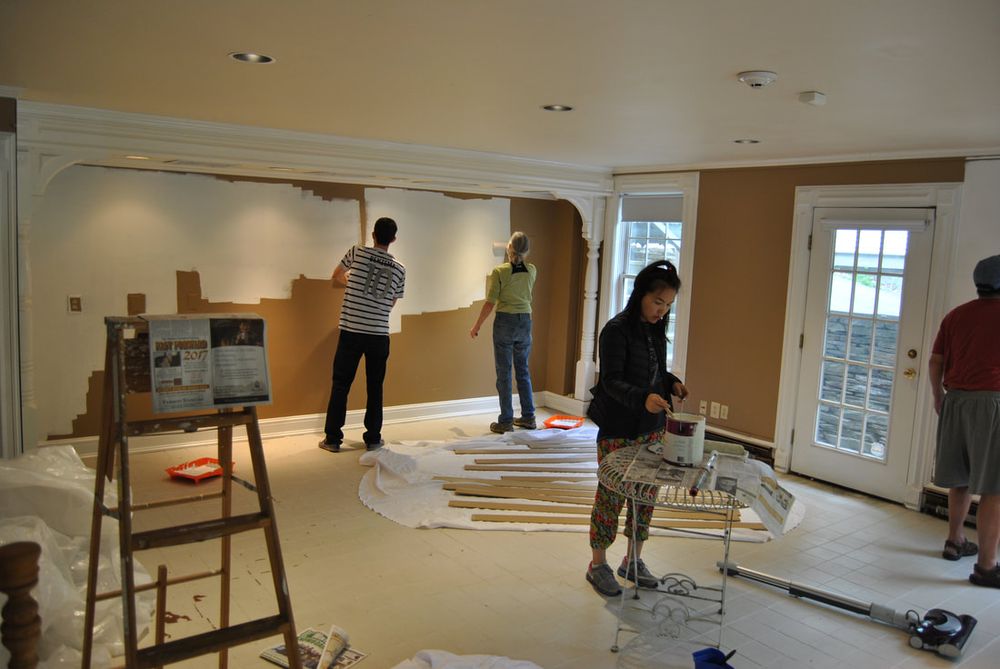Volunteers painting the brown walls of the idea room white