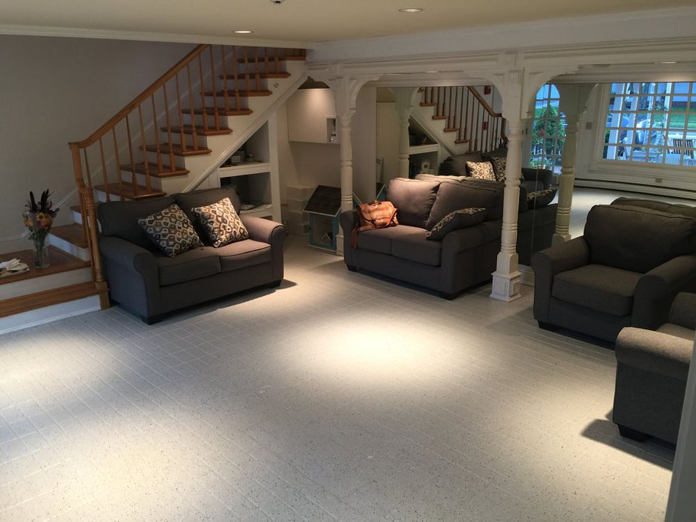Grey couches and armchairs beside the staircase