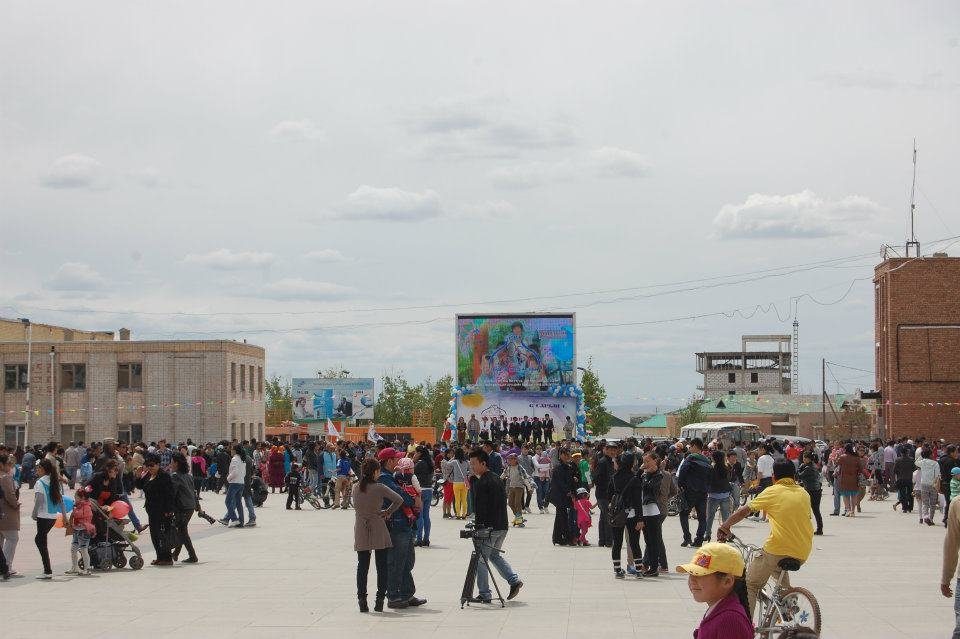 Crowds gather in the town square on Children&rsquo;s Day, with the large electronic billboard in the background